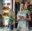 Gorgeous female florist communicating with clients on a smartphone while working in a flower shop and wearing an apron. The concept of a small flower delivery business - Effective Social Media Usage for Small Businesses